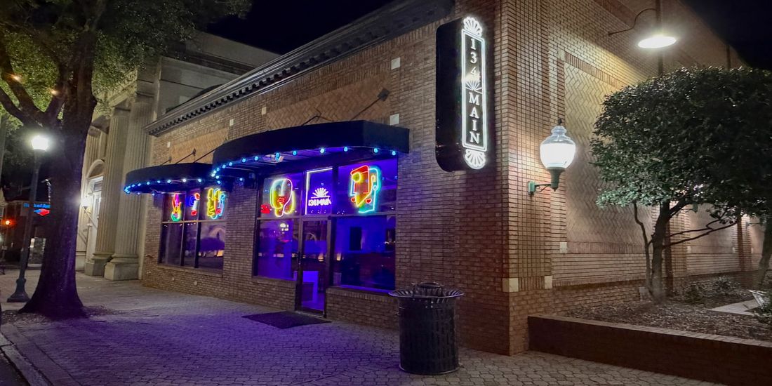 The illuminated "134 MAIN" sign above the venue’s entrance at night.