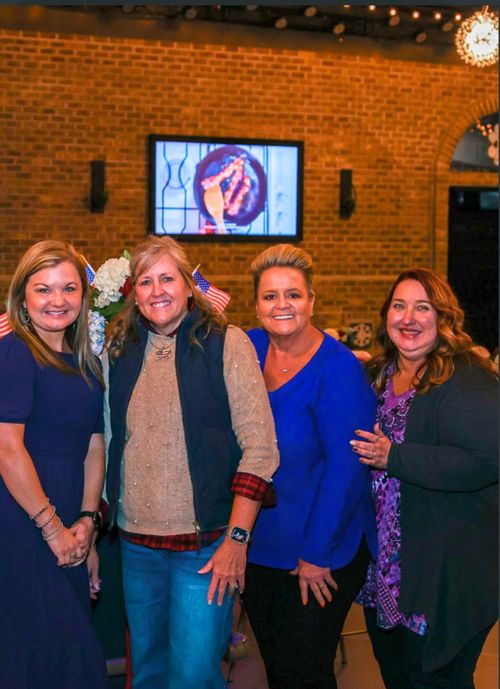 A group photo taken at a brick-walled GATHER venue.